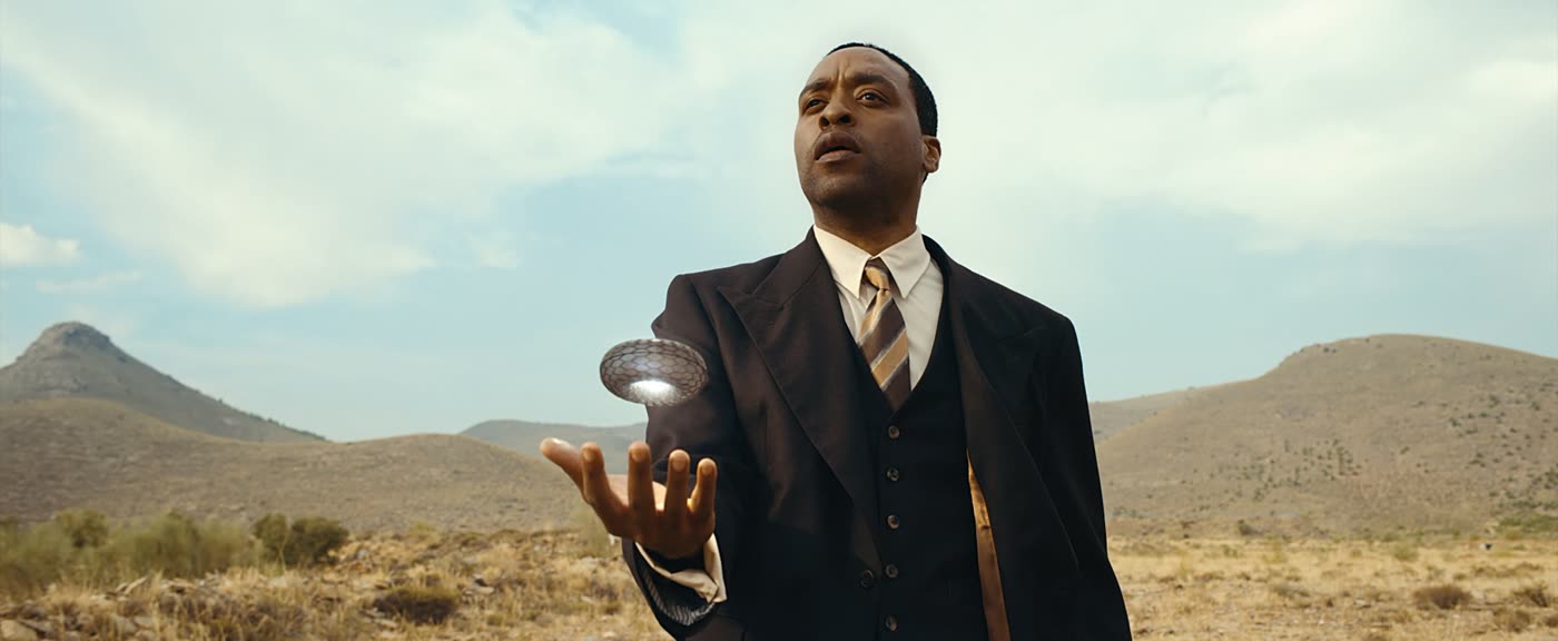 Chiwetel Ejiofor as Faraday holding a levitating alien object in a desert landscape, from The Man Who Fell to Earth.